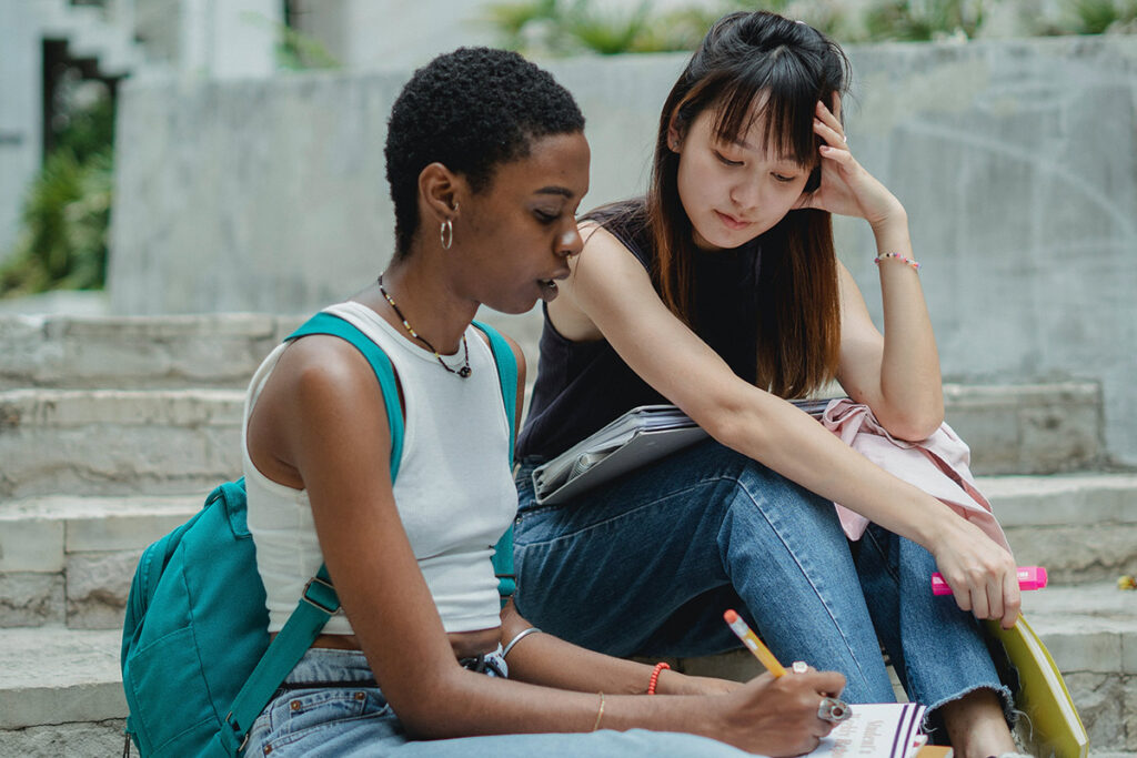 Two college girls sitting on steps