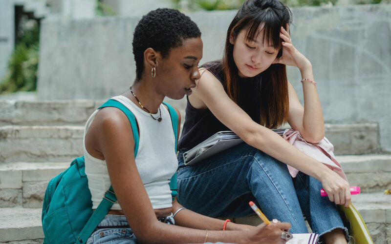 Two college girls sitting on steps