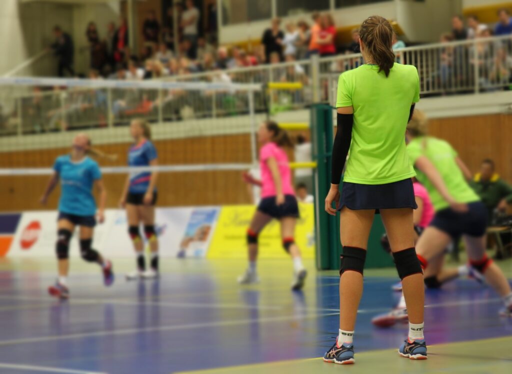 Girls playing volleyball in gym