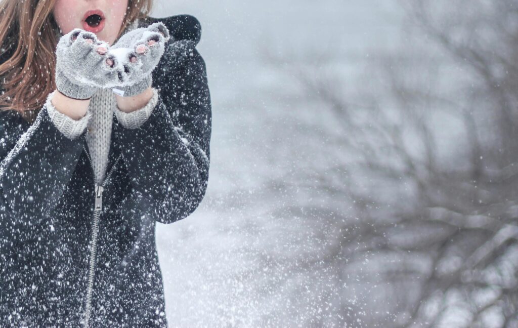 Woman in snow warming hands